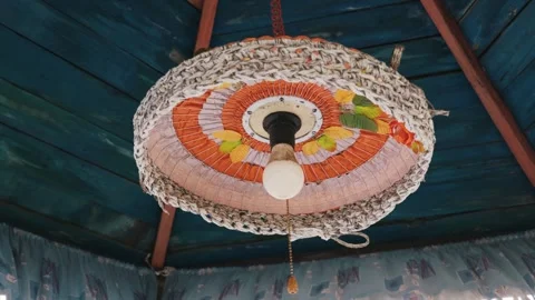 Handmade Rustic Lampshade Hanging from a Blue Painted Wooden Ceiling Stock Footage 334120707
