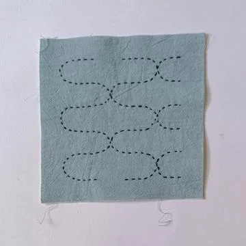 Handmade Sashiko Embroidery Sampler on Light Blue Fabric.  Stock Photos