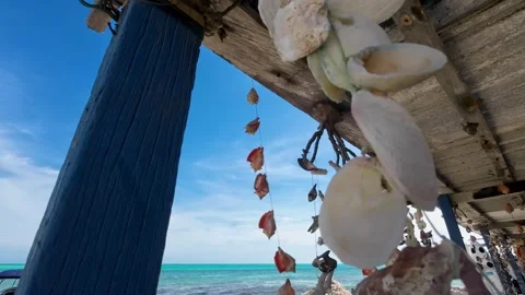 Handmade seashell decor move with sea breeze beachfront house, Los Roques, Stock Footage 278511377