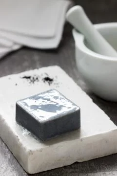 Handmade soap with activated carbon on marble, carbon powder and a cotton towel Stock Photos