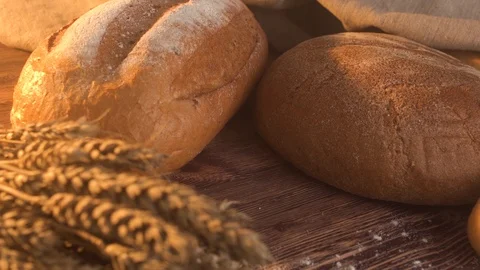 Handmade tasty bread lying on burlap on the wooden table with flour, wheat and 스톡 동영상 86019077
