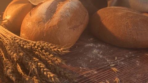 Handmade tasty bread lying on burlap on the wooden table with flour, wheat and Stock Footage 86019179