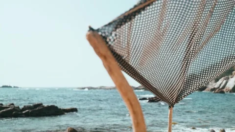 Handmade tent on the beach. The wind blows a piece of cloth tied to sticks Stock Footage 189394874