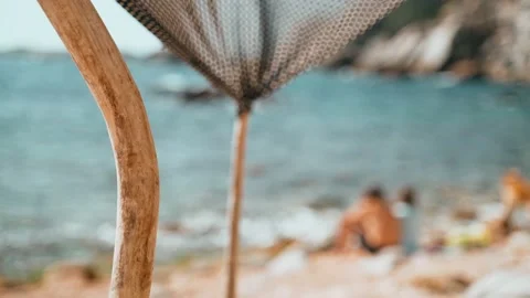 Handmade tent on the beach. The wind blows a piece of cloth tied to sticks Stock Footage 191486353