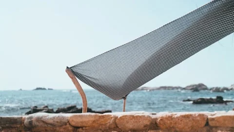 Handmade tent on the beach. The wind blows a piece of cloth tied to sticks Stock Footage 191486624