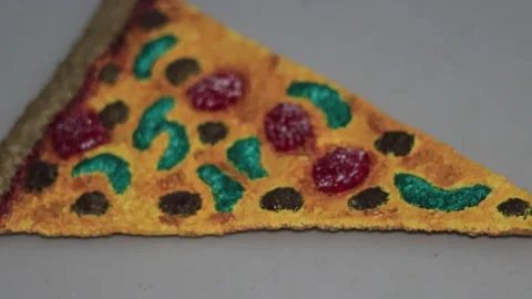 A handmade textile art piece depicting a slice of supreme pizza. Stock Footage 337506053