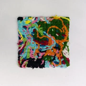 Handmade Textile Coaster Made from Leftover Yarn.  Stock Photos