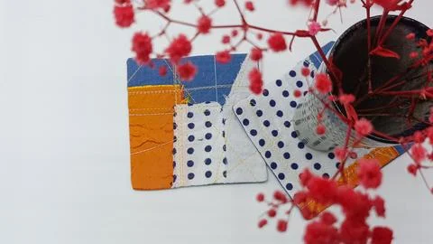 Handmade textile pieces including patchwork fabric squares and embroidered coast Foto stock