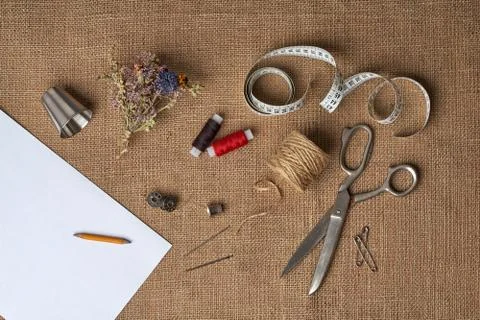 Handmade tools: thimble, thread, needle, pin, tape measure, paper, pencil Stock Photos