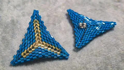 Handmade triangle earrings made of beads and glass beads, blue and gold Stock Photos