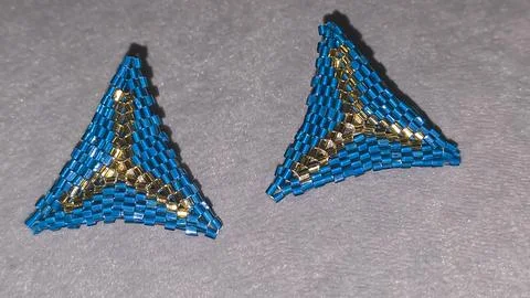 Handmade triangle earrings made of beads and glass beads, blue and gold Stock Photos