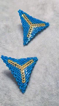 Handmade triangle earrings made of beads and glass beads, blue and gold Stock Photos