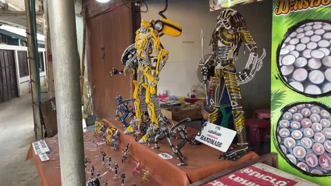 Handmade wire cartoon model figure of robot standing for sale near alley daytime Stock Footage 255829859