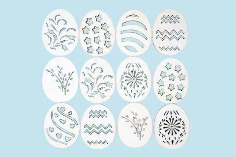 Handmade wooden Easter eggs with patterns on a blue background. 库存照片