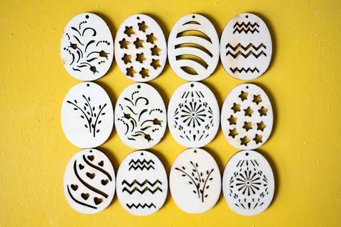 Handmade wooden Easter eggs with patterns on a yellow background. 库存照片