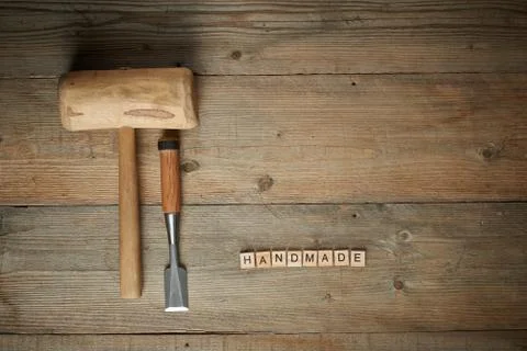 Handmade word with mallet and chisel on a wooden workbench,  top view Stock Photos