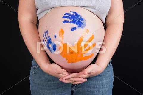 Handprints on belly isolated on black background Stock Photos