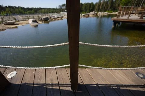 A handrail post on a bridge with ropes stretched against the background of water Stock Photos