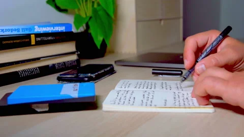 Handrwriting in notebook or diary, human hands on desk Stock Footage 149599196