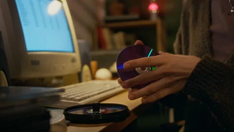 Hands of 90s Woman Searching Stack of CDs while Working on Old Computer Stock Footage 327240763