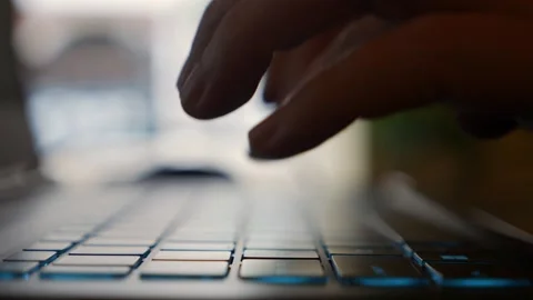 Hands actively type on a laptop keyboard in a cafe as a woman completes work Video stock 325310963