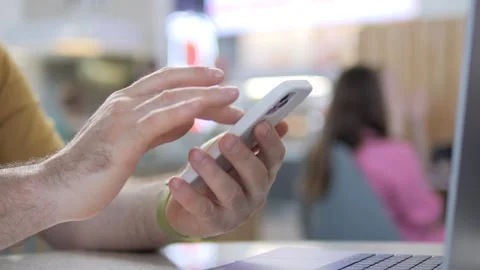 Hands actively using phone while laptop open Stock Footage 342587411