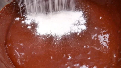Hands adding flour into a bowl with melted chocolate preparing for makes brownie Stock Footage 158660321