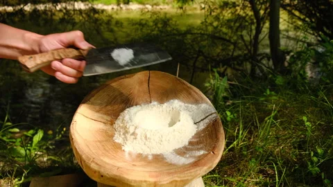 Hands adding salt and oil to flour in plate preparing dough for baking outdoors Stock Footage 333768064