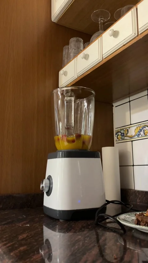 Hands adding strawberries to blender with juice vertical shot Stock Footage 345661156