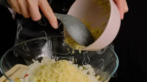 Hands Adding Yellow Crumbs to Rice Mix in Cooking Scene Video stock 341461888