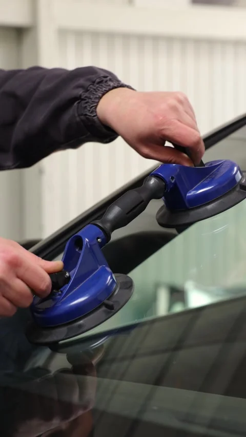 Hands adjust blue squeegee on car windshield Video stock 335408898