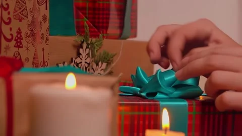 Hands adjusting the bow on a box containing a Christmas present Stock Footage 295279418