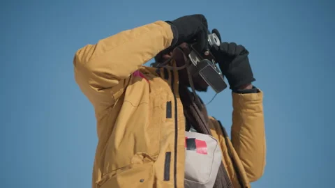 Hands adjusting camera lens and pressing shutter trigger under winter sun Stock Footage 318627177