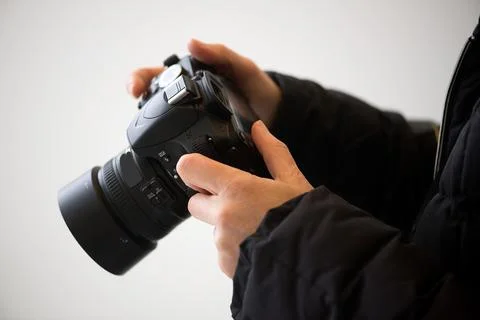 Hands Adjusting Camera Settings In Soft Natural Light 库存照片
