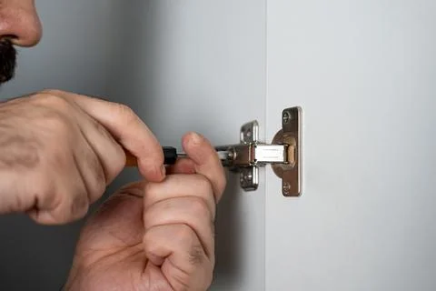 Hands Adjusting Metal Cabinet Hinge Stock Photos