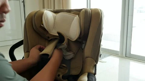 Hands Adjusting Padding on Infant Car Seat in Bright Interior Setting Video stock 337140510