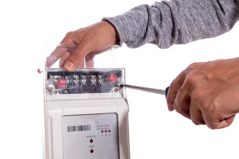 Hands adjusting with screwdriver an electric light meter, isolated on white Foto stock