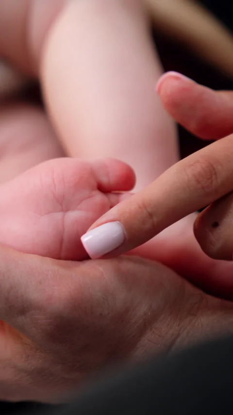 Hands of adults touching cute tiny newborn's feet. Stock Footage 296771829