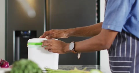 Hands of african american man composting waste in kitchen Vídeo Stock 342111020