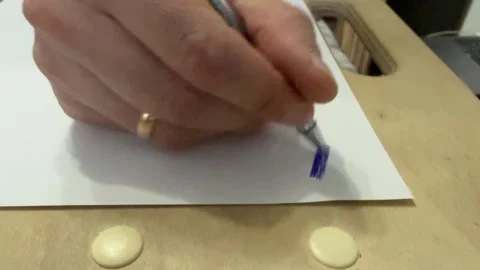 Hands aggressively scribbling on a sheet of paper using a pen Stock Footage 336524164
