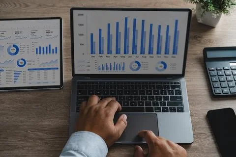 Hands analyzing financial data on laptop and tablet screens with charts, da.. Stock Photos