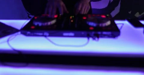 Hands and DJ console at work. DJ playing at a party, close-up. Stock Photos
