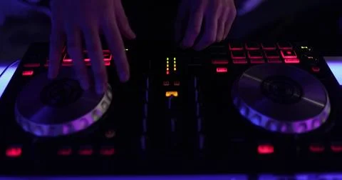 Hands and DJ console at work. DJ playing at a party, close-up. Stock Photos
