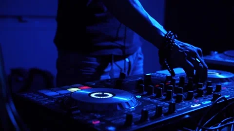 Hands and fingers of man syncing and equalizing settings on digital DJ Stock Footage 214586761