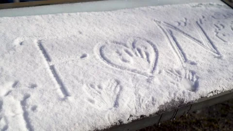 Hands and initials drawn on snow from a young romantic couple in love in winter Stock Footage 262220882