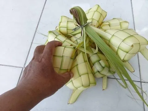 Hands and ketupat shells Stock Photos