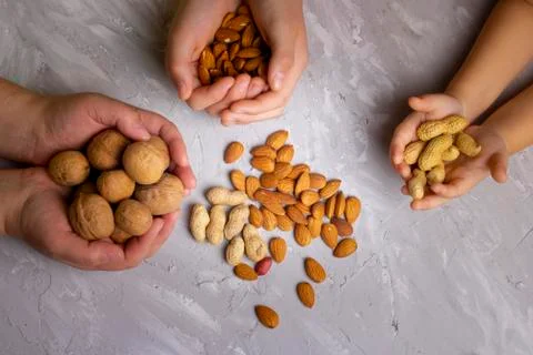 Hands and mixed hazelnuts, walnuts, cashews, almonds. Flat lay Stock Photos