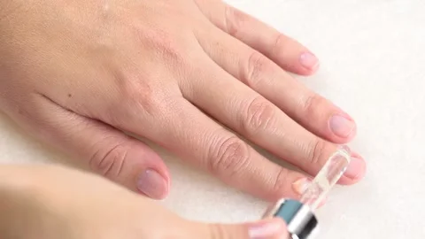 Hands and nails care concept. A woman using a pipette applies moisturizer s.. Stock Footage 284420640