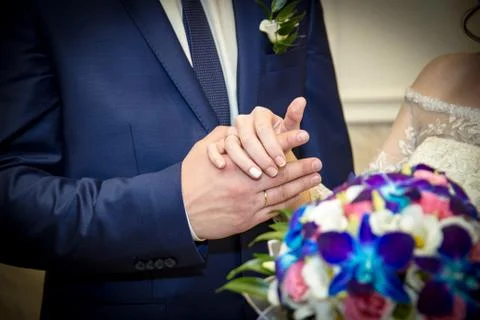 Hands and rings bride groom on the background of a wedding bouquet. Foto stock