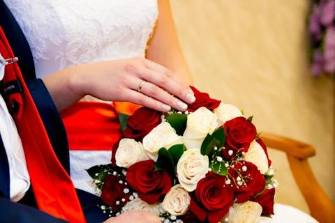 Hands and rings bride groom on the background of a wedding bouquet. Foto stock